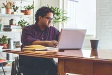 man sitting at desk with laptop