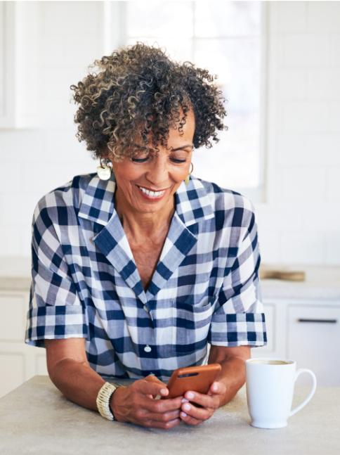 Woman in kitchen looking at phone