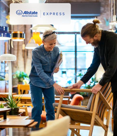 Furniture sales associate helps woman with chair