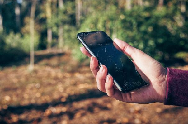 hand holding phone with cracked screen